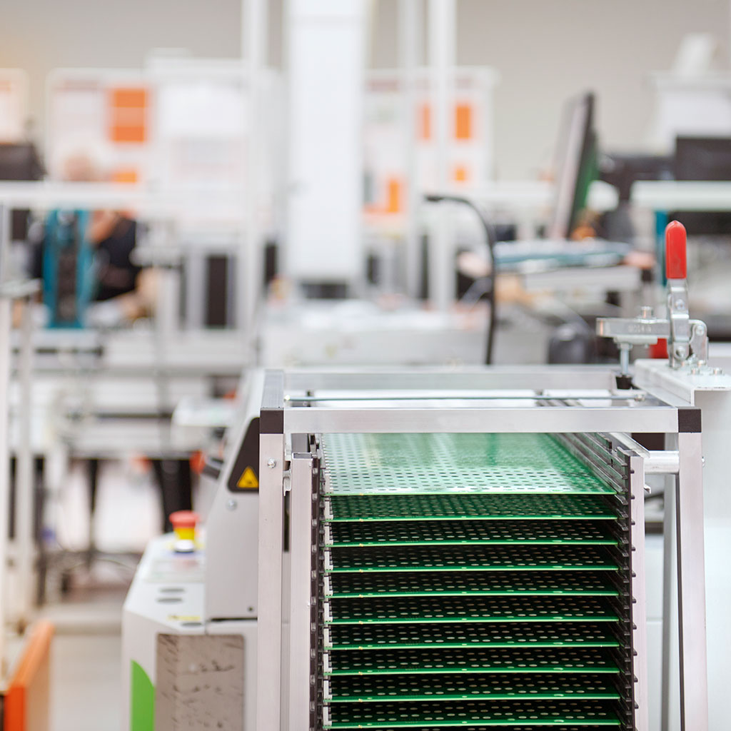 Stacked green circuit boards in a production facility