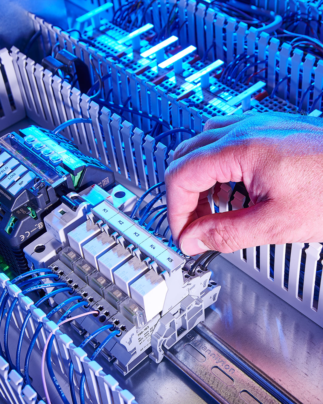 Hand plugs cable into a control unit with relays and connections